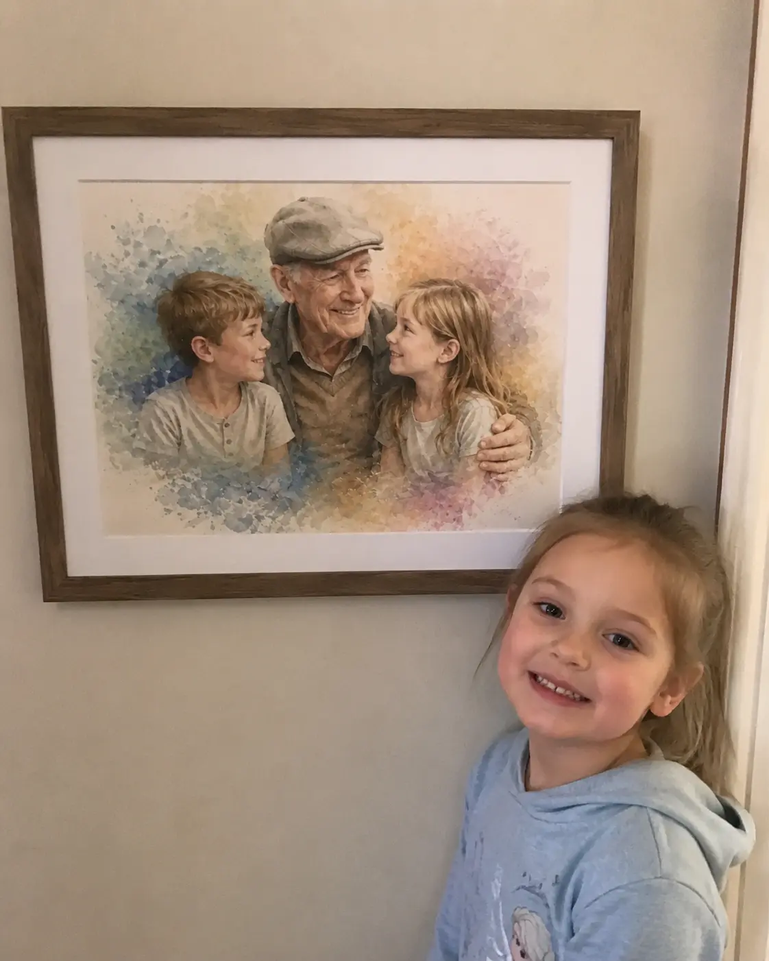 A young granddaughter standing next to a framed watercolour portrait of her late grandad with her and her brother — painted from separate photos